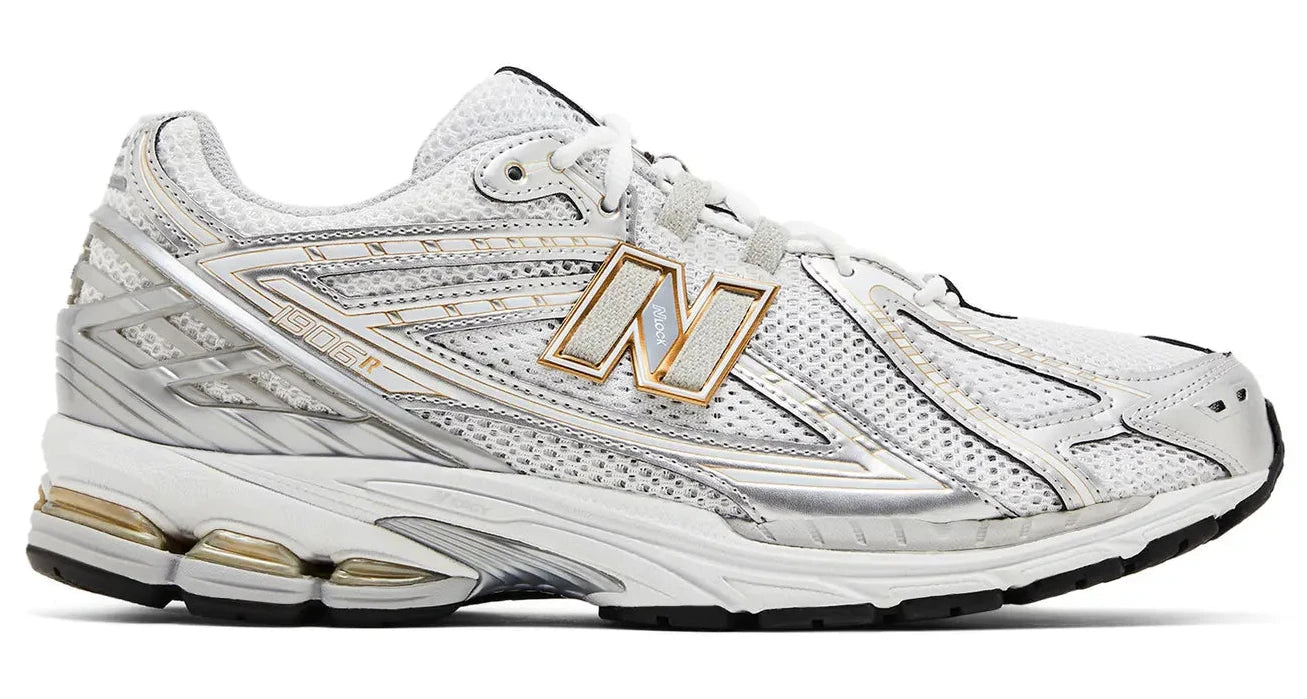 White athletic shoe with gold accents on a white background