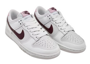 White sneakers with maroon swoosh logo on a white background