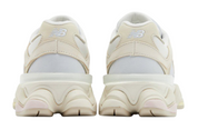 Pair of beige sneakers with white soles on a white background