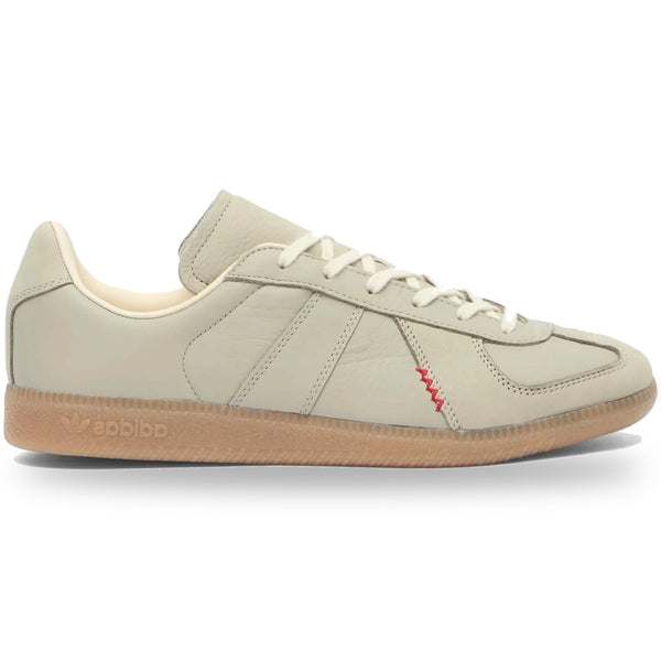 Beige Adidas sneaker with a red accent on a white background