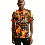 Person wearing a black and orange patterned sports jersey with visible branding on a white background - Image 1
